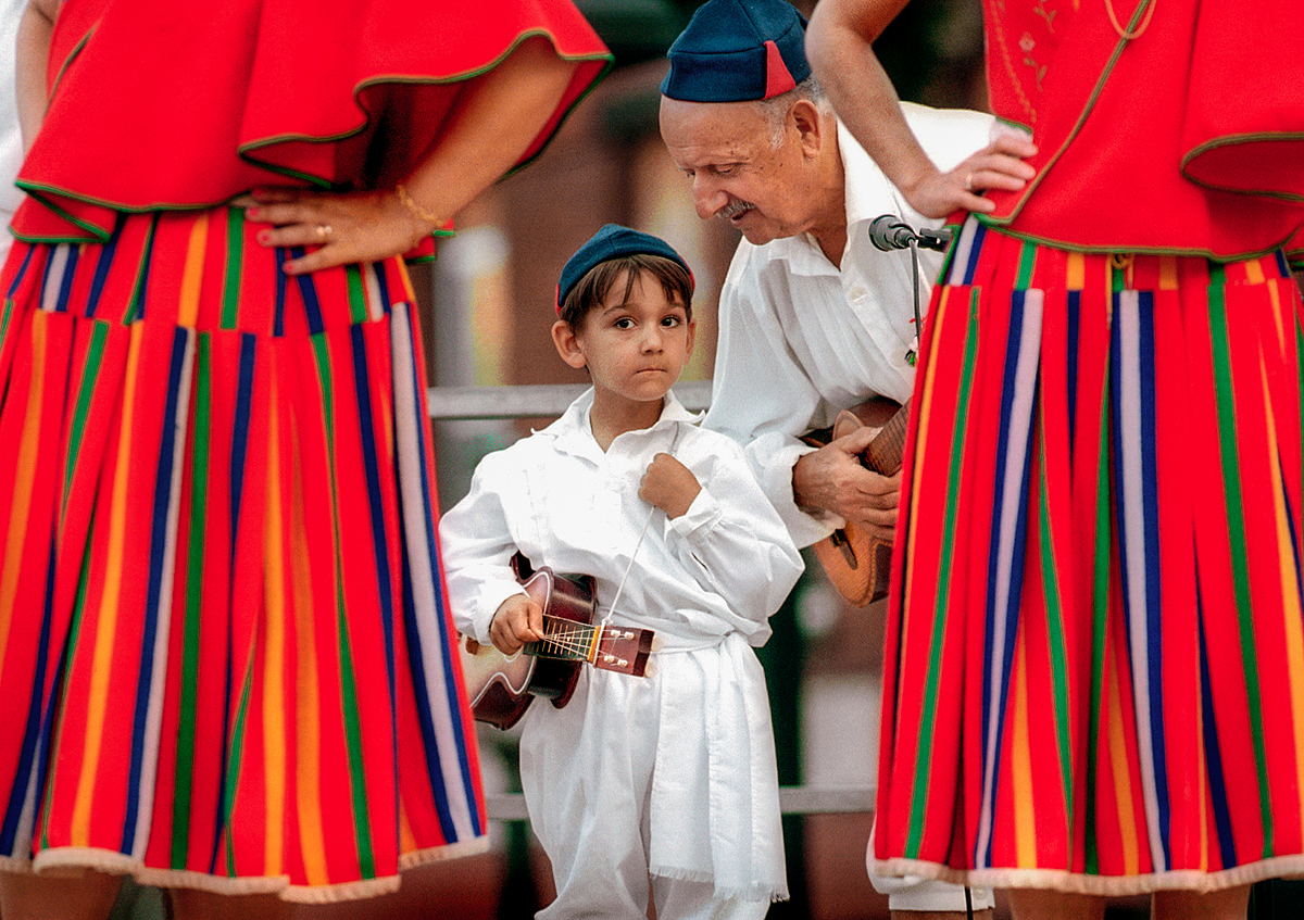 (7-13-00) dave_in / aha / ready.jpg
Staff / DAVID ARRUDA, JR.
---------
Framed by colorful skirts worn by traditional Azorean dancers, Joe Ponte of New Bedford offers some last minute pointers to his grandson Jason Ponte, 5, also of New Bedford, as their group, The Madeiran Folkloric Group of New Bedford, prepares to take the stage at Custom House Square.